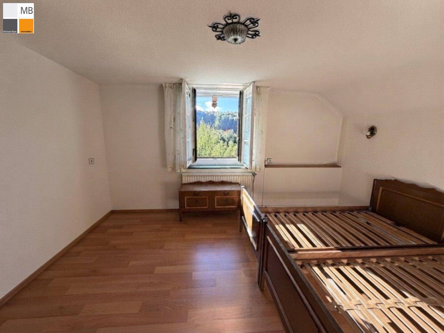 Helles Schlafzimmer mit Laminatboden und zwei Einzelbetten, bietet einen schönen Ausblick.