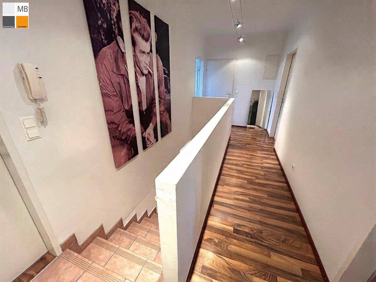 Flur mit Holzboden und Treppenabgang, dekoriert mit einem großen Wandbild.