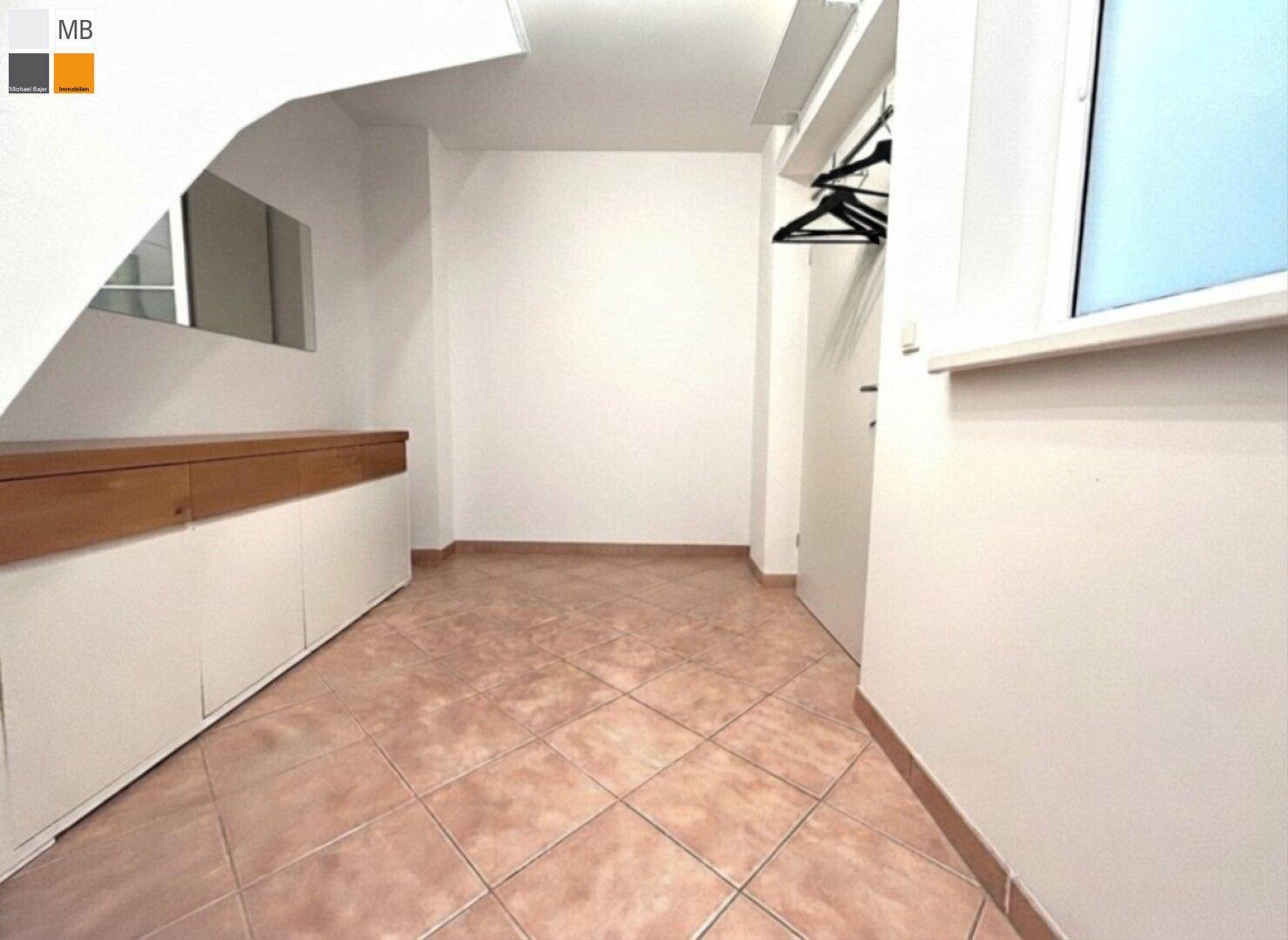 Praktischer Abstellraum mit Fliesenboden und Ablagemöglichkeiten unter der Treppe.
