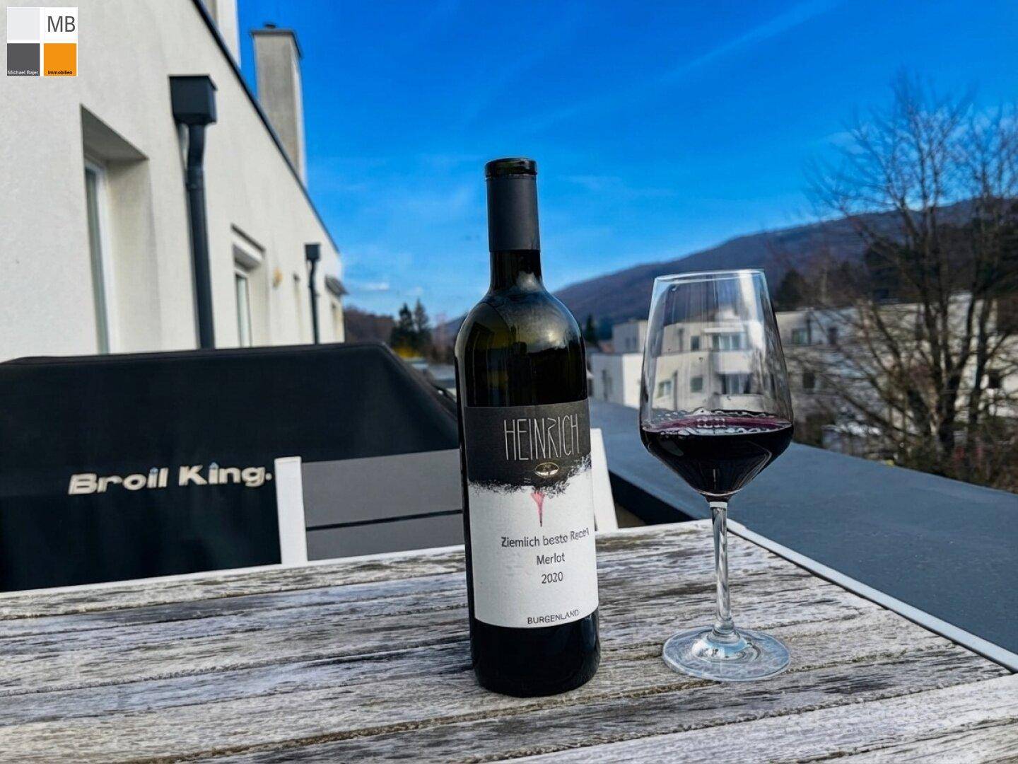 Gemütliche Terrasse mit Holztisch, Grill und Blick auf die umliegende Landschaft und Berge.