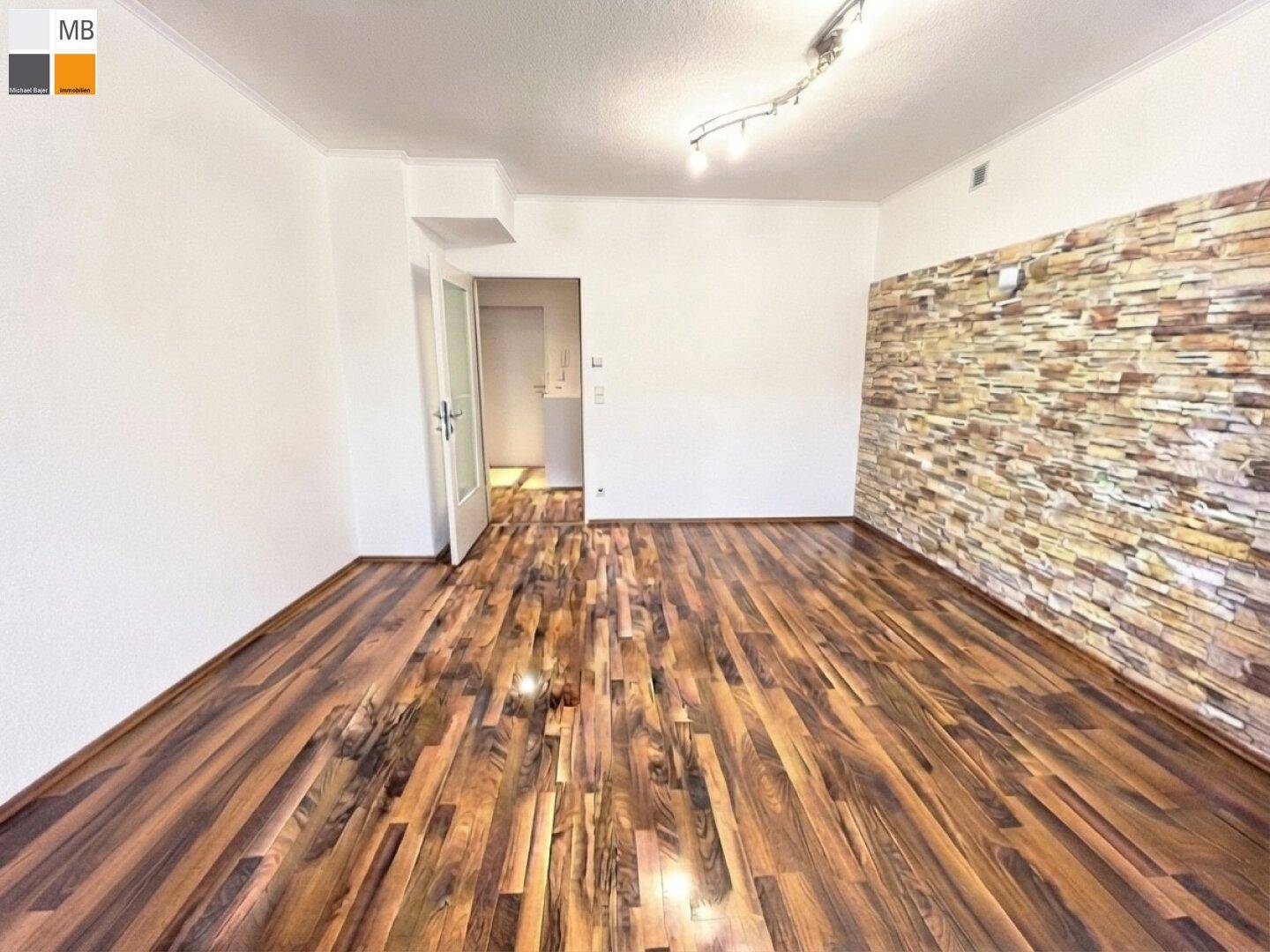Heller Wohnraum mit Holzboden und einer dekorativen Steinwand, die einen Akzent setzt.