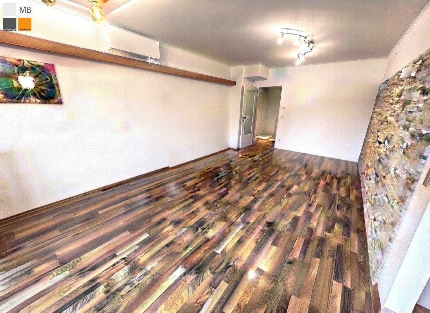 Geräumiger Wohnbereich mit glänzendem Holzboden und weiß gestrichenen Wänden.