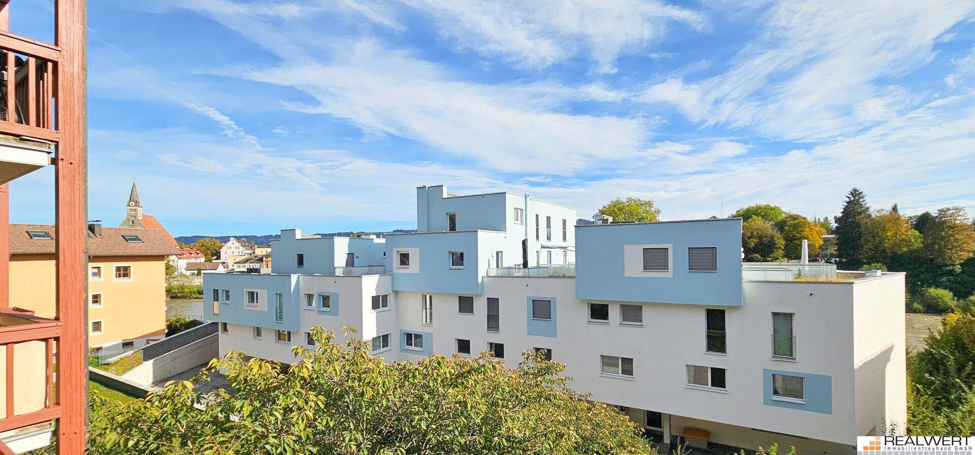 Weitblick auf moderne Gebäude mit blauen Akzenten und umliegende Landschaft unter blauem Himmel.