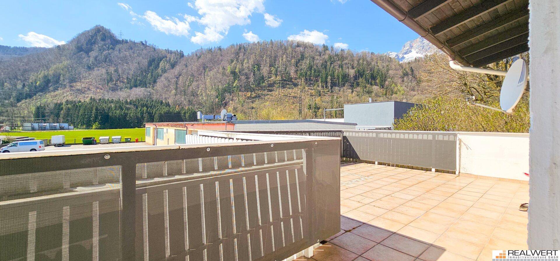 Große Terrasse mit Fliesenboden und einem weiten Blick auf die umliegende Berglandschaft.