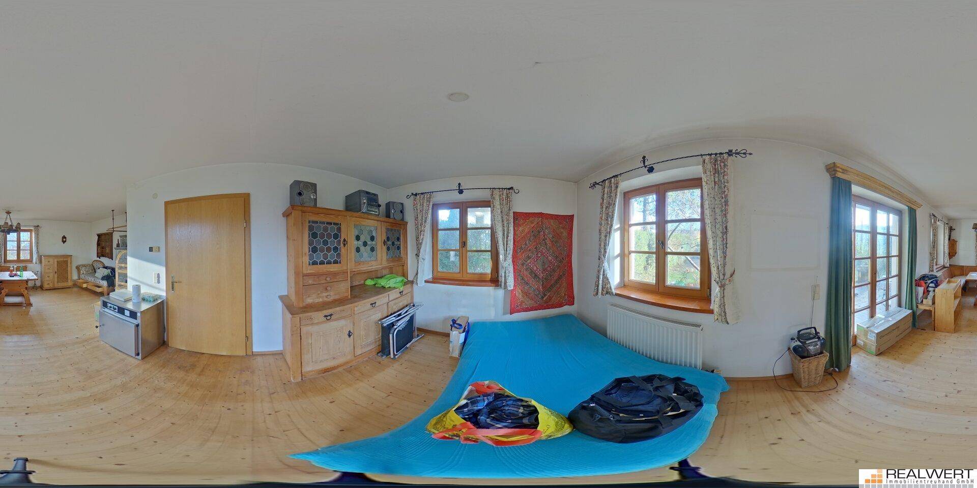 Panoramaansicht eines Schlafzimmers mit Holzboden, großen Fenstern und einfacher Einrichtung.