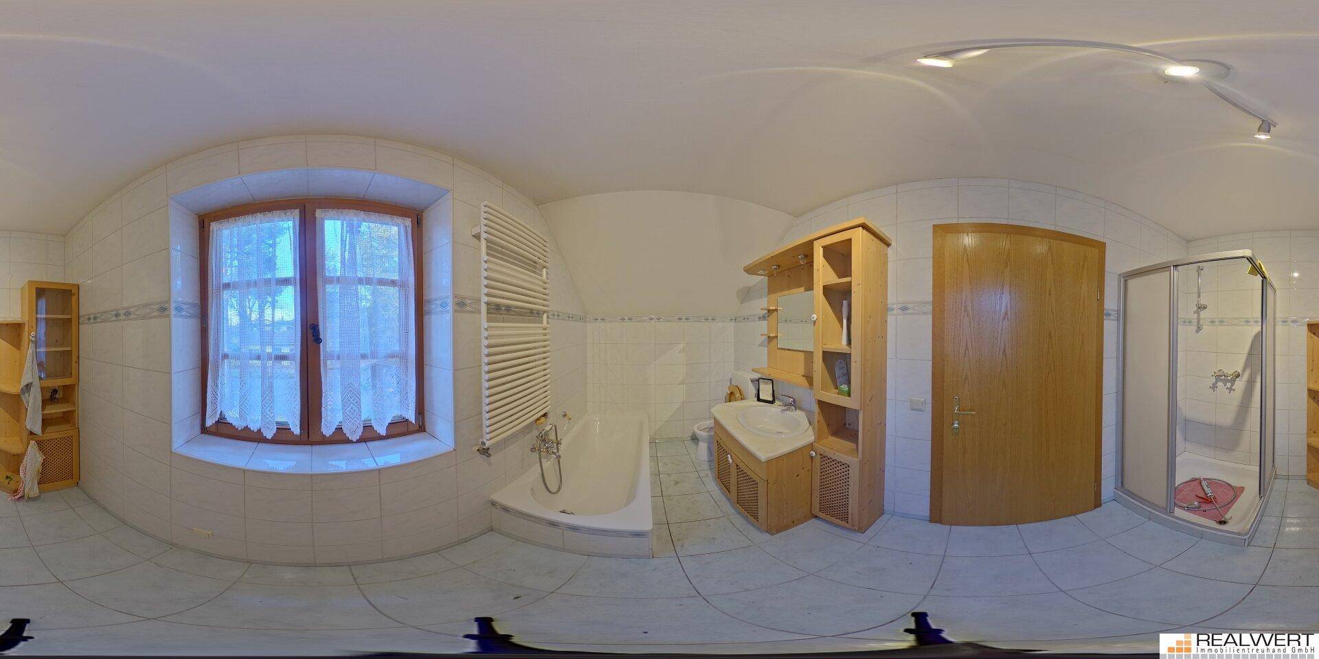 Panoramaansicht eines hellen Badezimmers mit Badewanne, weißen Fliesen und Holzmöbeln.