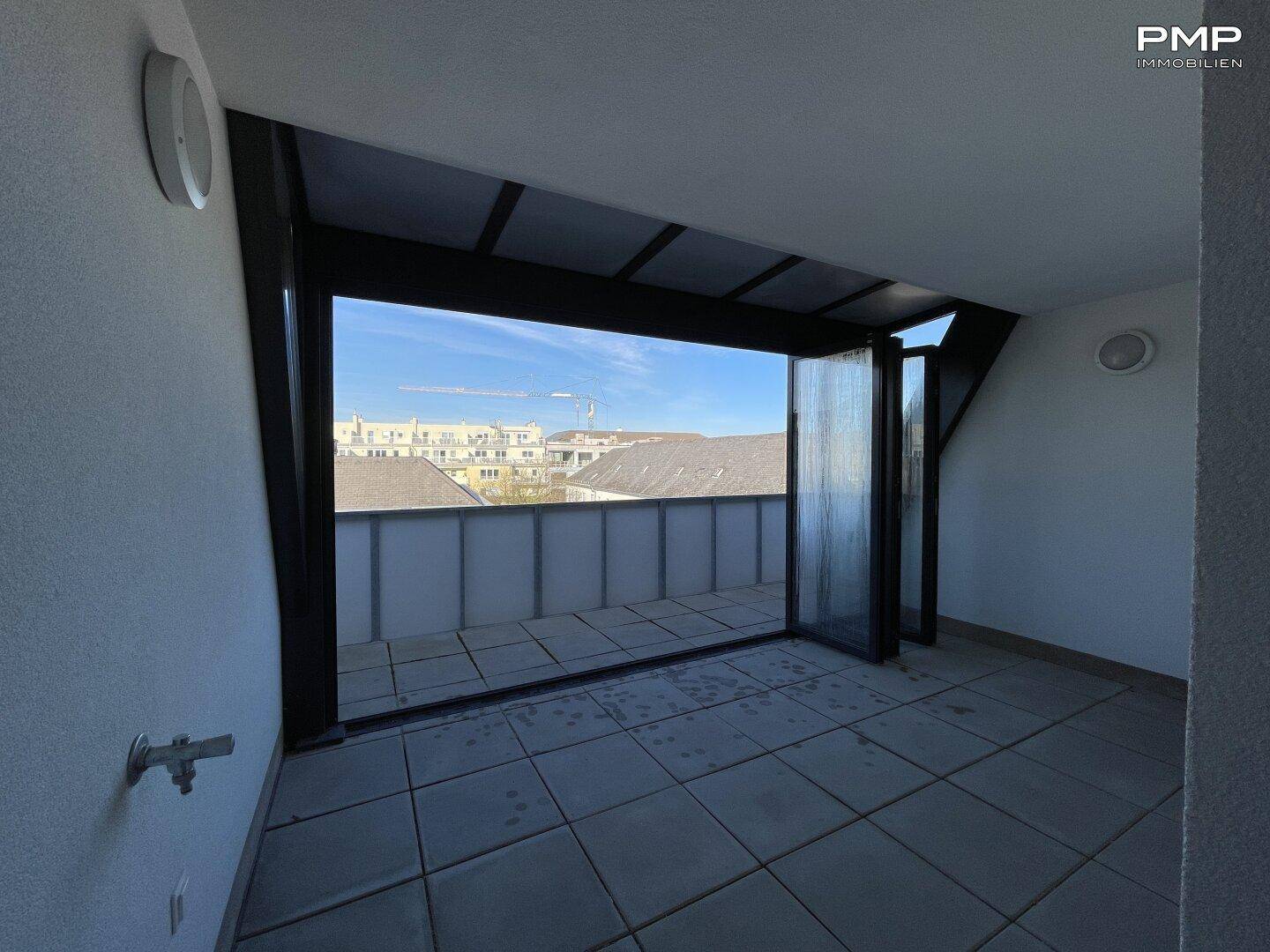 Geräumige Dachterrasse mit Fliesenboden und weitem Blick über die Dächer der Stadt.