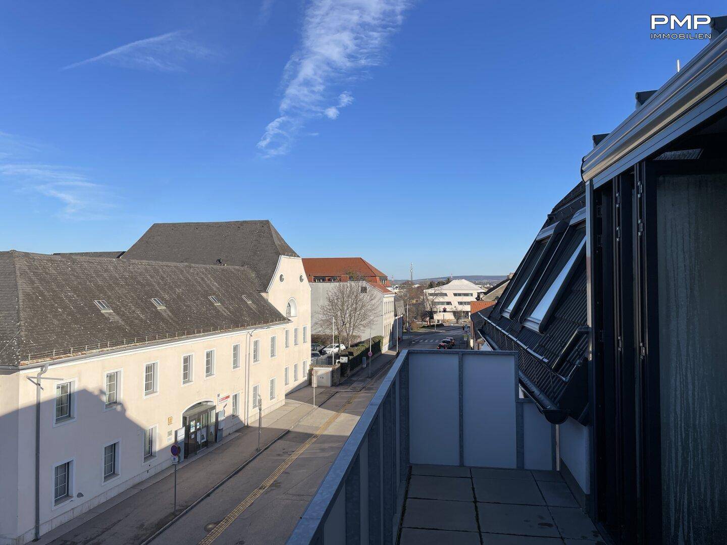 Sonniger Ausblick von der Dachterrasse auf die umliegenden Gebäude und die Stadt.