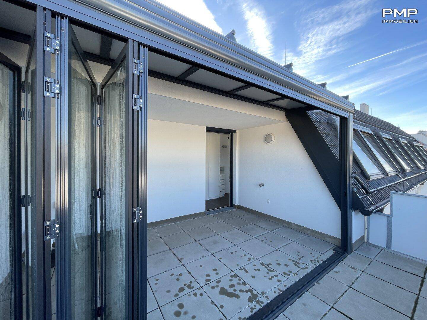 Dachterrasse mit faltbaren Glasfronten, die einen flexiblen Außenbereich schaffen.