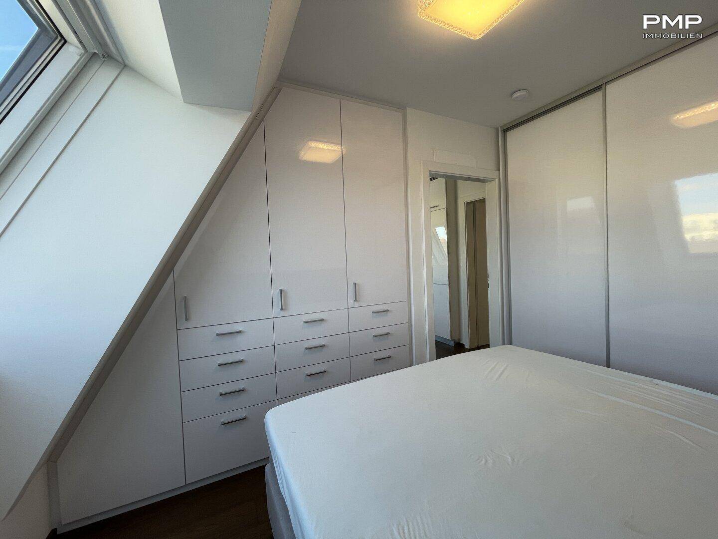 Schlafzimmer mit Einbauschränken und Dachschrägen, die den Raum gemütlich gestalten.