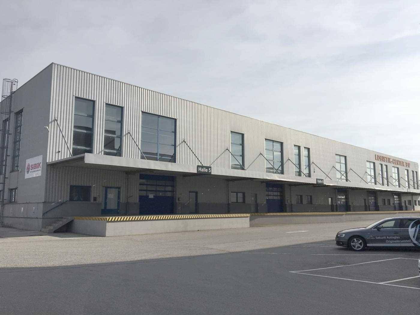 Lange Lagerhalle mit mehreren Laderampen und großen Rolltoren für den Güterverkehr.