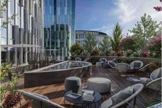 Moderne Dachterrasse mit bequemen Loungemöbeln, Holzboden und Blick auf die umliegenden Gebäude.