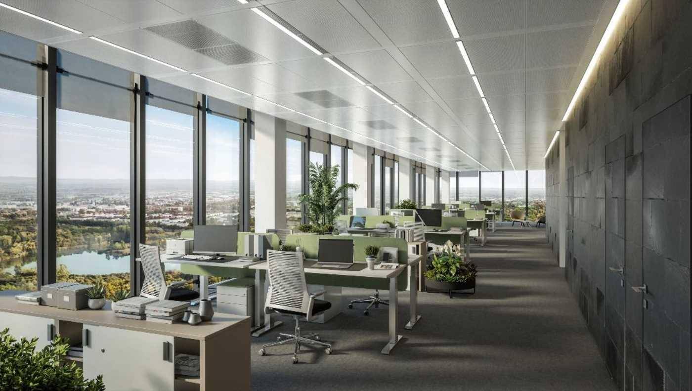 Großzügiges Großraumbüro mit vielen Arbeitsplätzen, Pflanzen und weitem Blick auf die Landschaft und einen See.