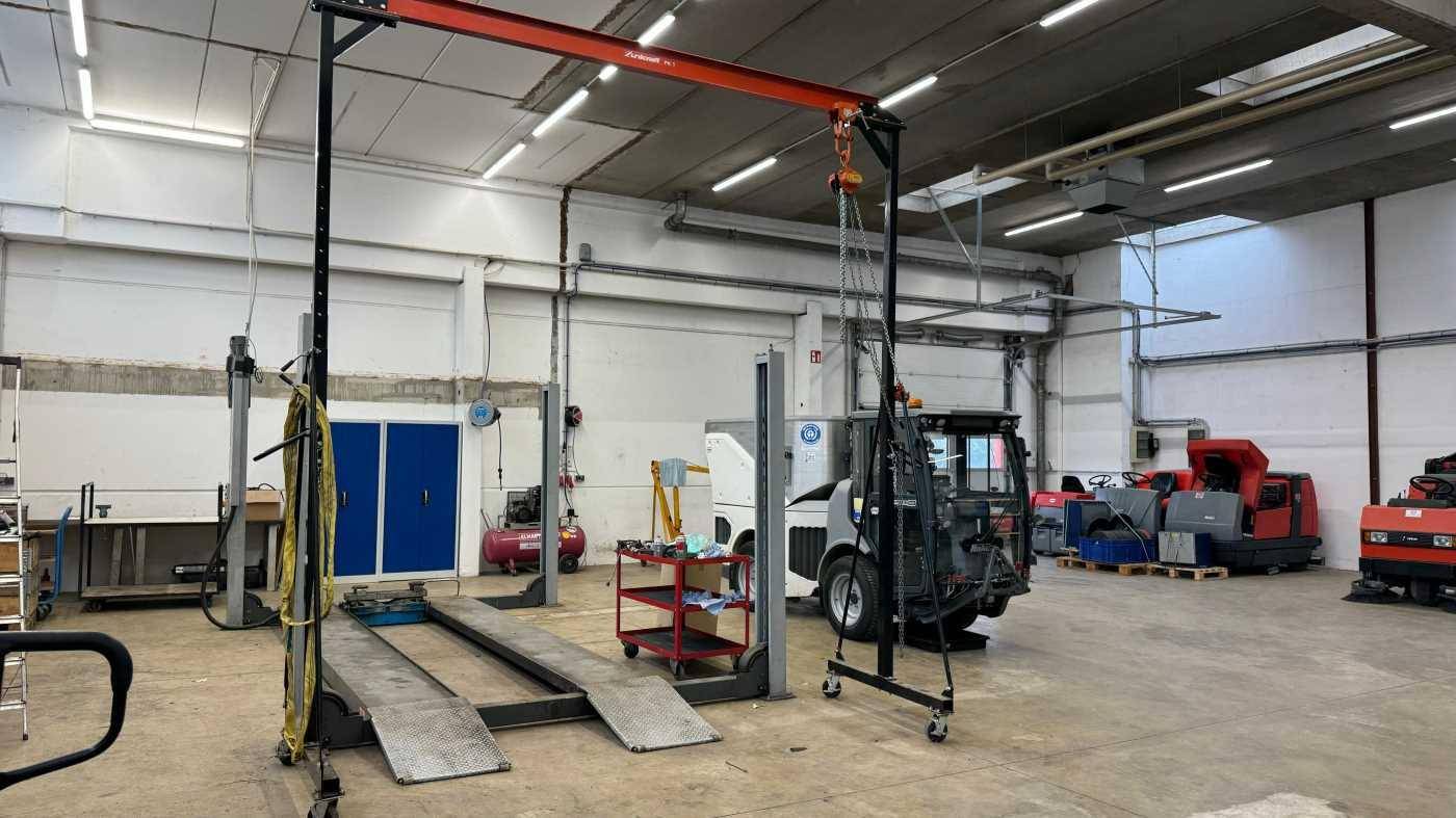 Werkstatt mit Hebebühnen, Krananlage und industrieller Ausstattung für Reparaturen.