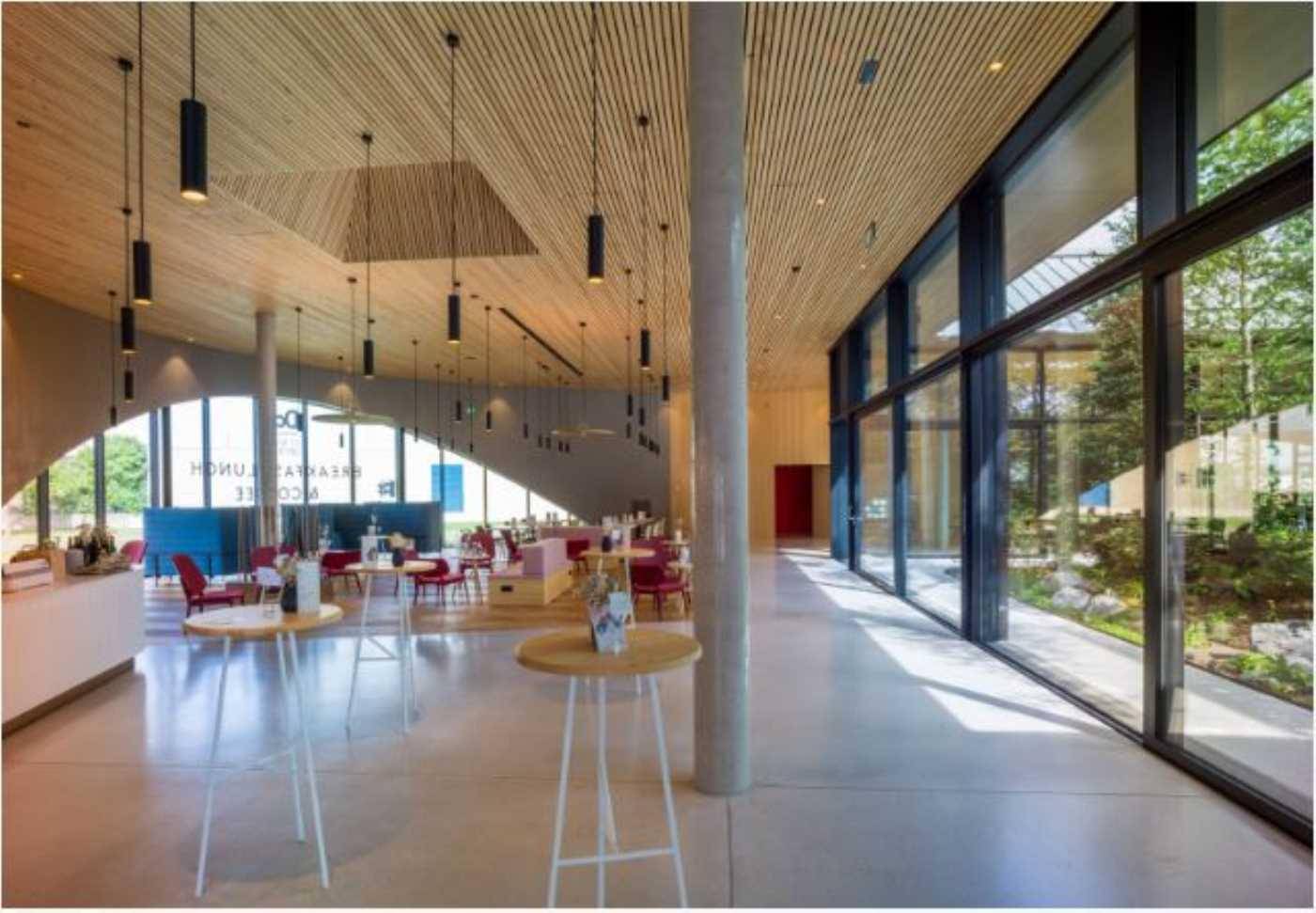 Großzügiger Empfangsbereich oder Lounge mit hoher Holzdecke, modernen Pendelleuchten und bodentiefen Fenstern.