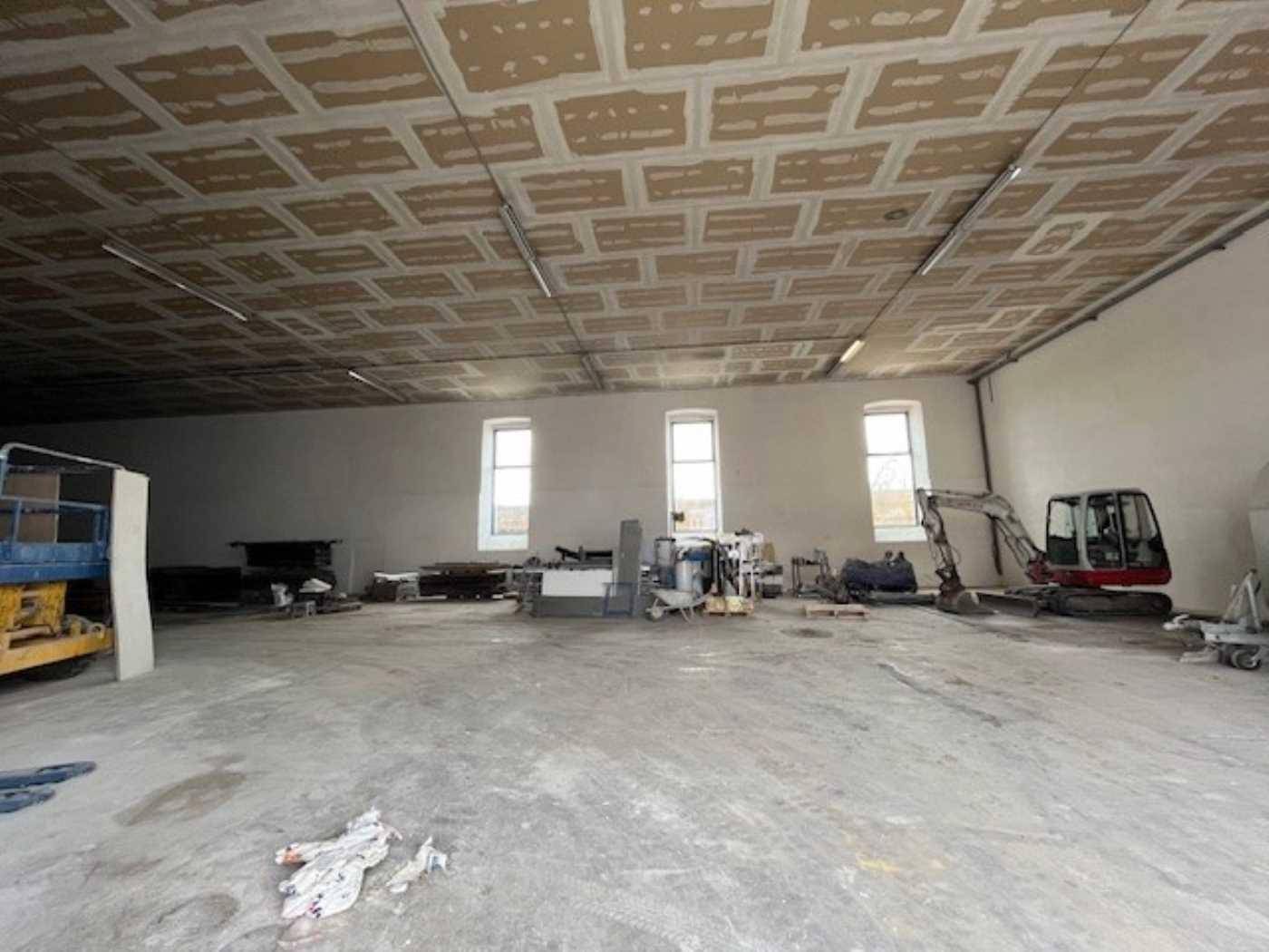 Geräumiger Lagerraum im Rohbau mit Betonboden und sichtbaren Deckenplatten, bereit für den Ausbau.