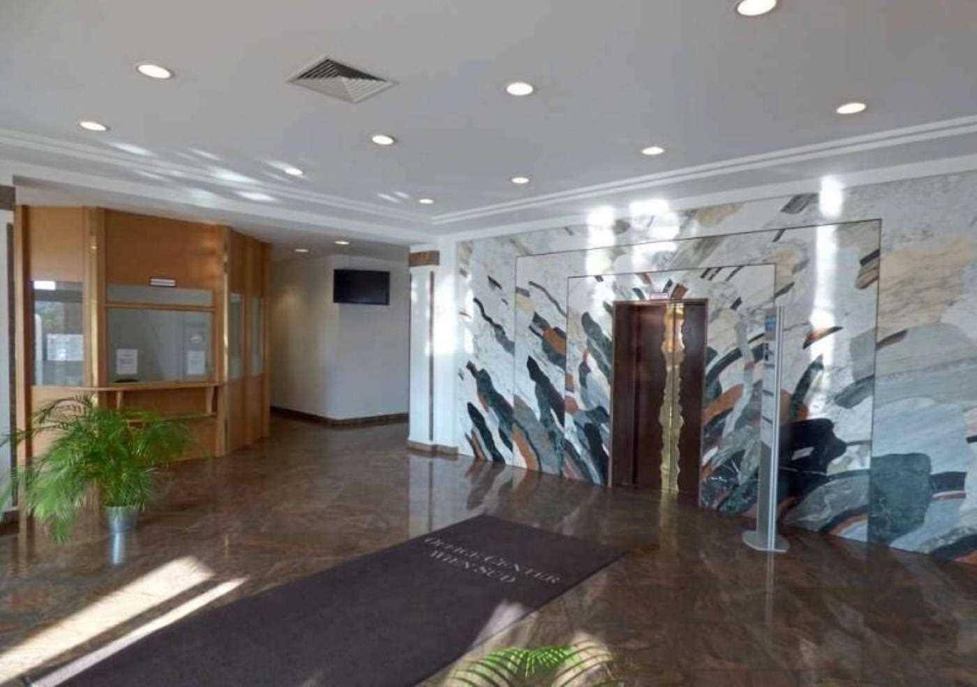 Elegante Lobby mit glänzendem Marmorboden, dekorativer Wandverkleidung und Aufzug, einladender Empfangsbereich.