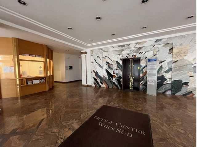 Helle und geräumige Lobby mit Marmorboden, Aufzug und Empfangsbereich, einladend für Besucher.