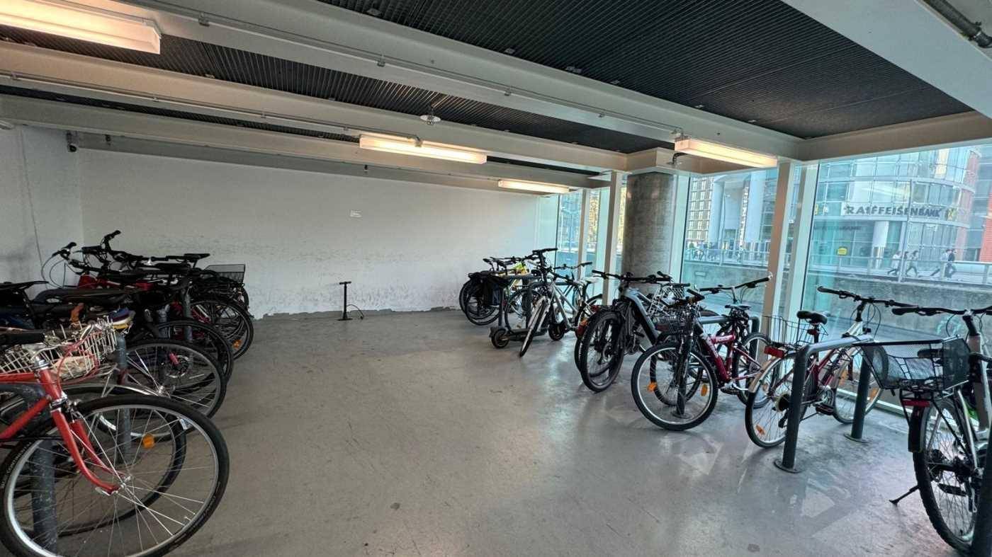 Fahrradraum mit zahlreichen Fahrrädern und großen Fenstern, der eine praktische Abstellmöglichkeit bietet.
