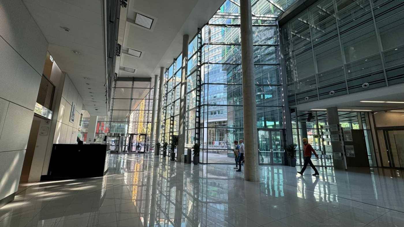 Weitläufige, lichtdurchflutete Lobby mit glänzenden Fliesenböden und beeindruckenden Glasfassaden.