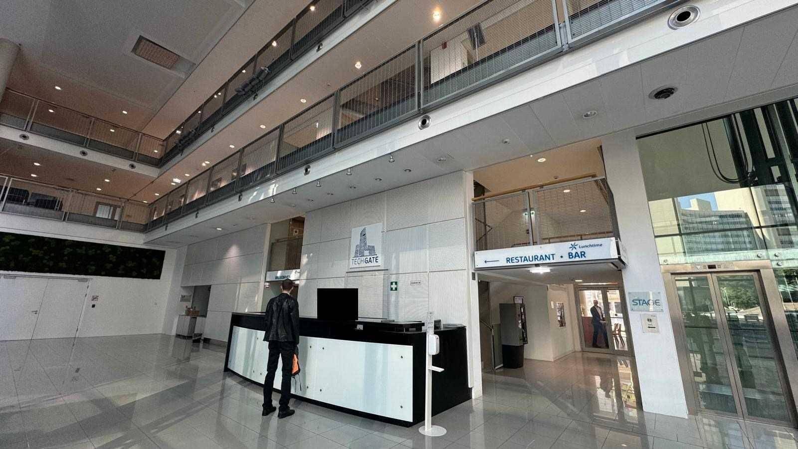 Geräumige, moderne Lobby mit Rezeption, hohen Decken und viel Tageslicht durch große Glasfronten.