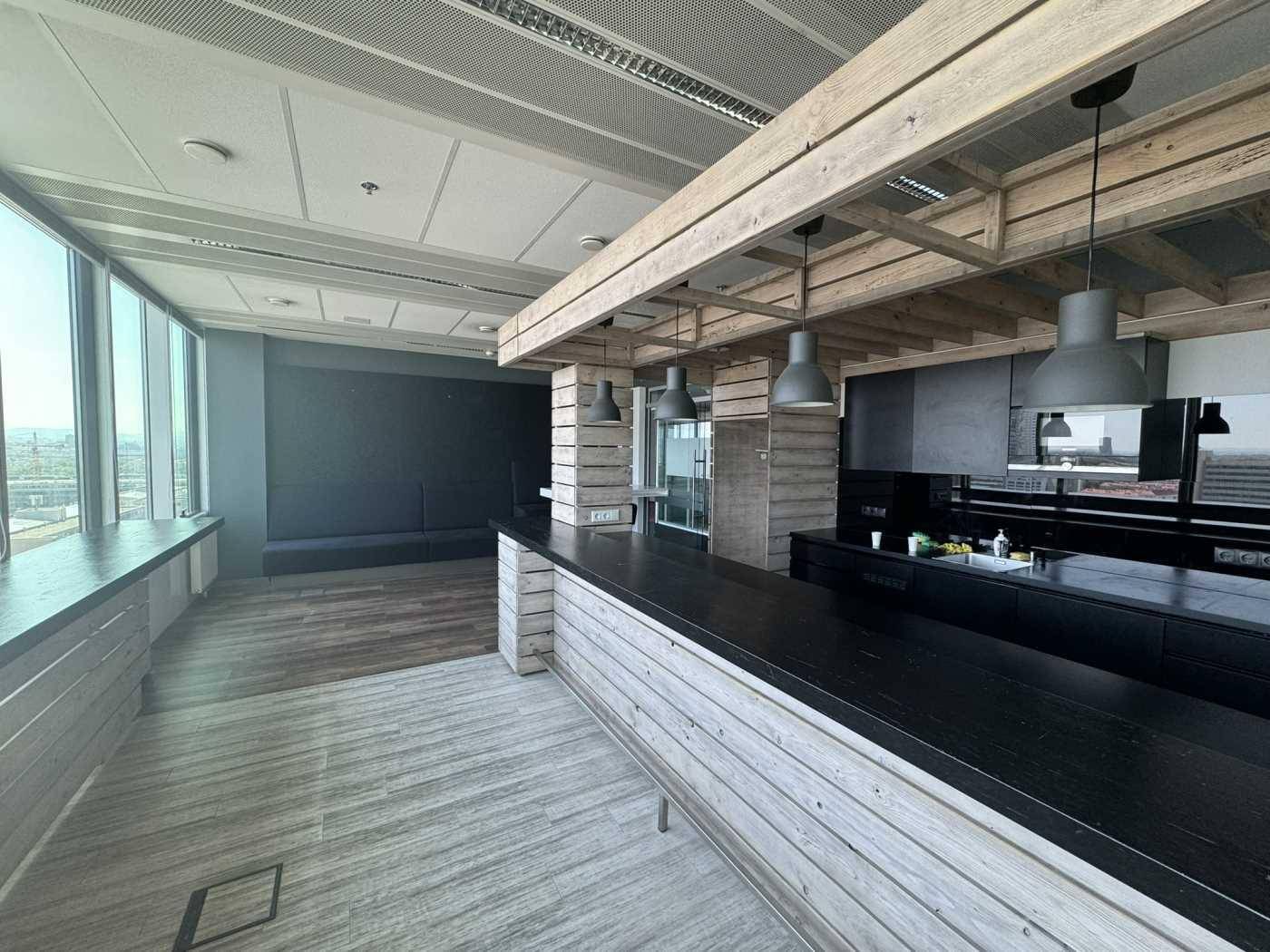 Moderne Küche oder Bar mit Holzelementen, dunklen Arbeitsplatten und großen Fenstern mit Aussicht.