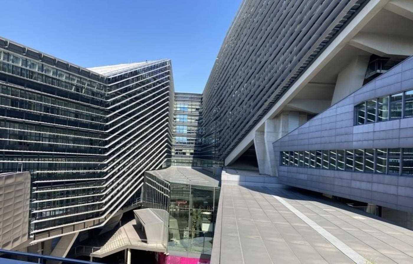 Komplexe Architektur des modernen Bürogebäudes mit schrägen Linien und Glasfassaden.
