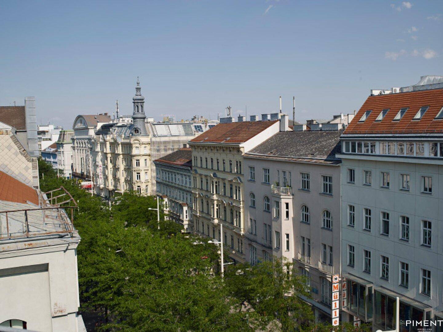 Panoramablick über die Dächer der Stadt mit historischen Gebäuden und Bäumen.