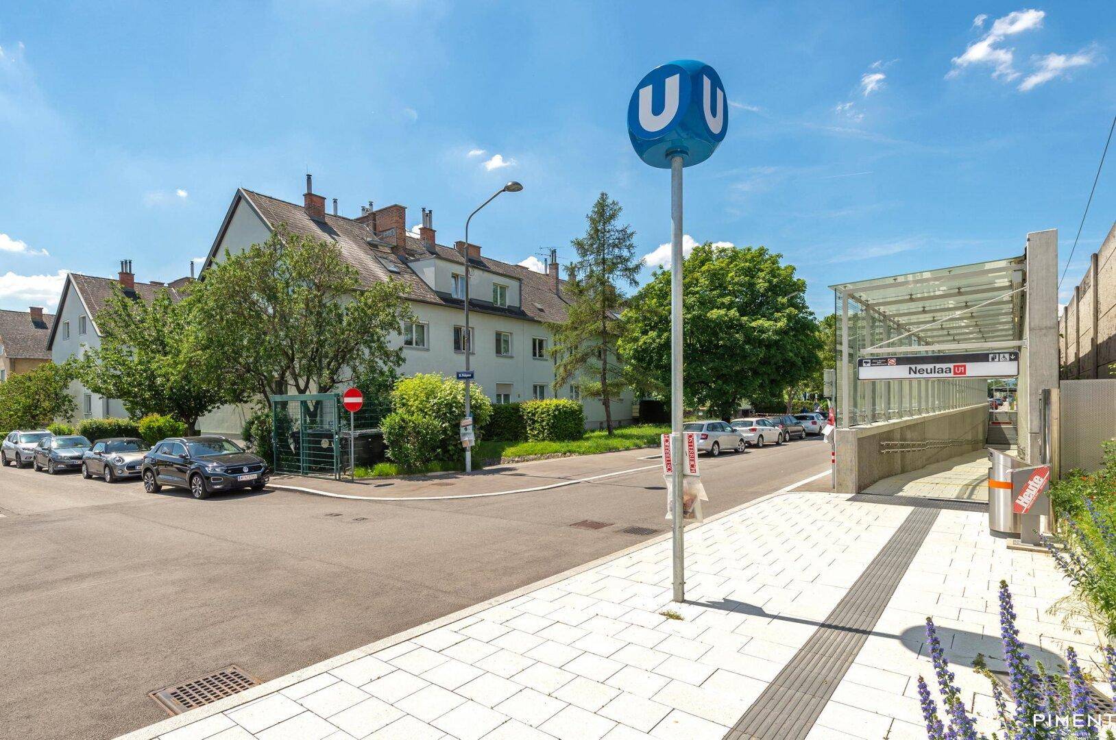 U-Bahn-Station Neulaa mit umliegenden Wohngebäuden und blauer Himmelskulisse.