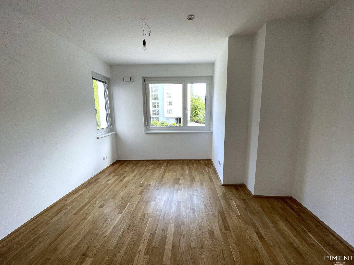 Freundliches Zimmer mit Parkettboden und hellen Wänden, bereit für individuelle Einrichtung.