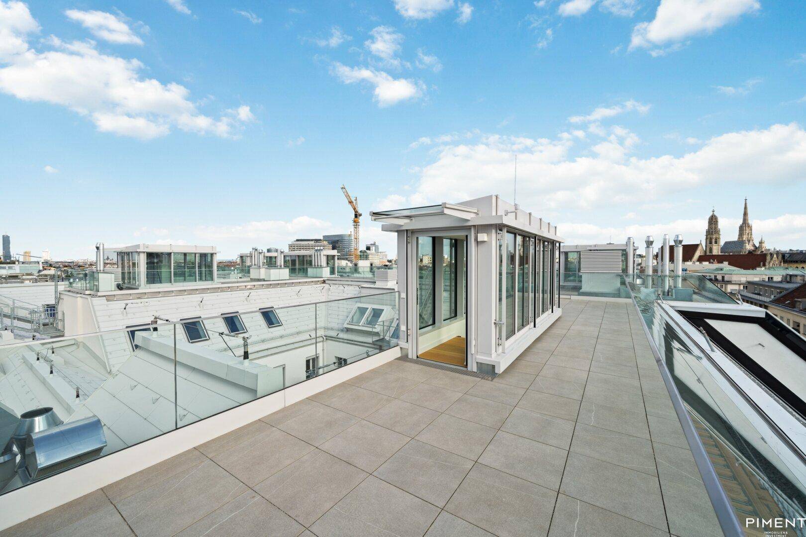 Dachterrasse mit modernem Zugangsbau und weitem Blick über die Stadt.