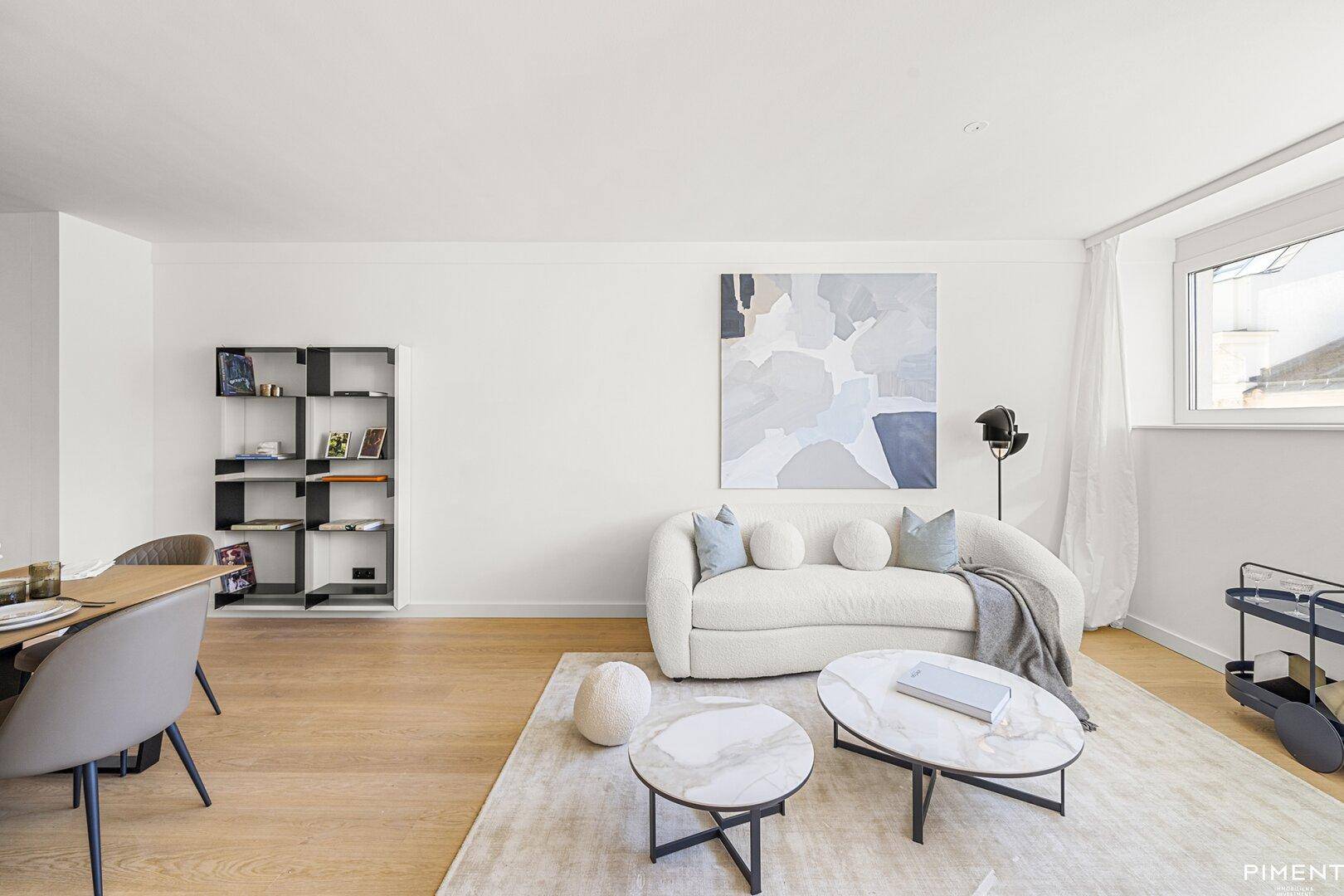 Gemütliches Wohnzimmer mit hellem Sofa, modernen Couchtischen und großem Fenster für viel Tageslicht.