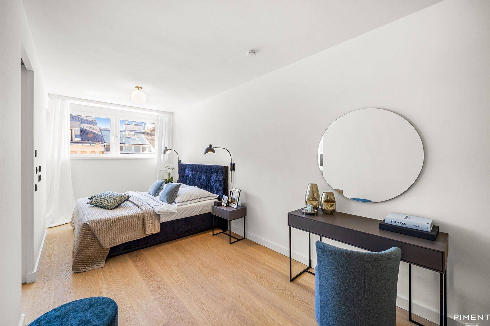Modernes Schlafzimmer mit Doppelbett, Schreibtisch und großem Fenster für viel Tageslicht.