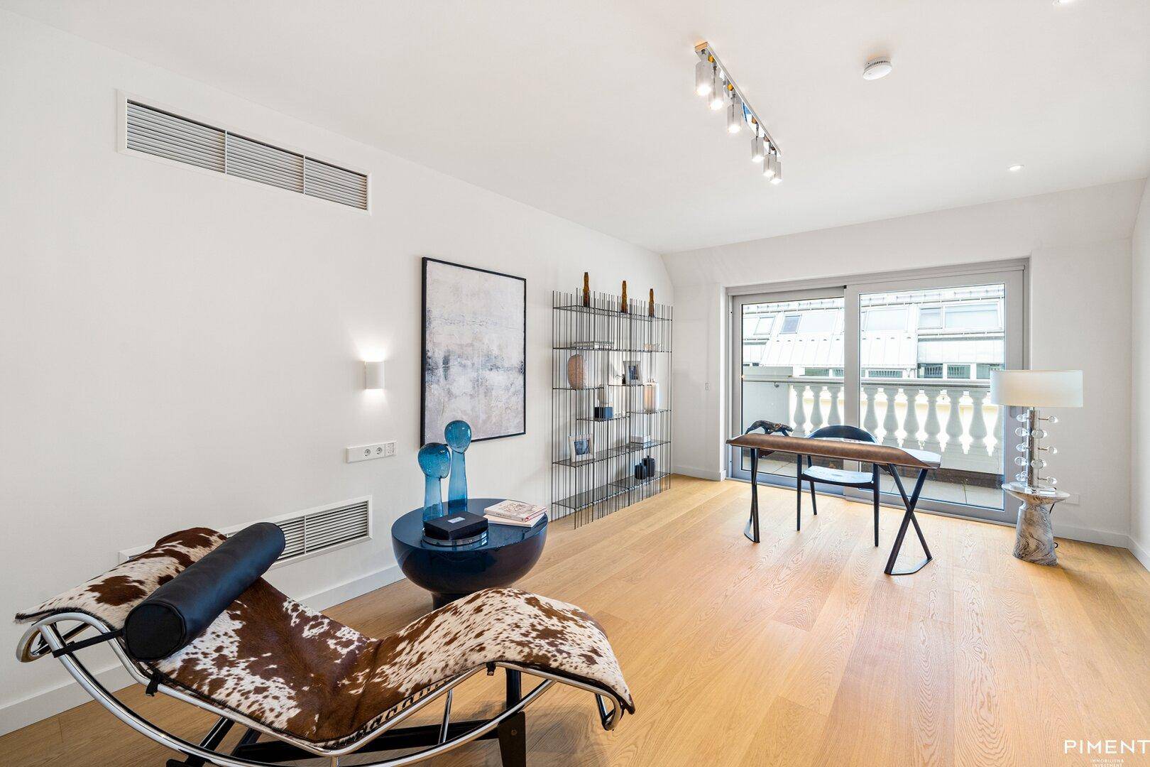 Helles Arbeitszimmer mit modernem Schreibtisch und Zugang zu einem französischen Balkon.