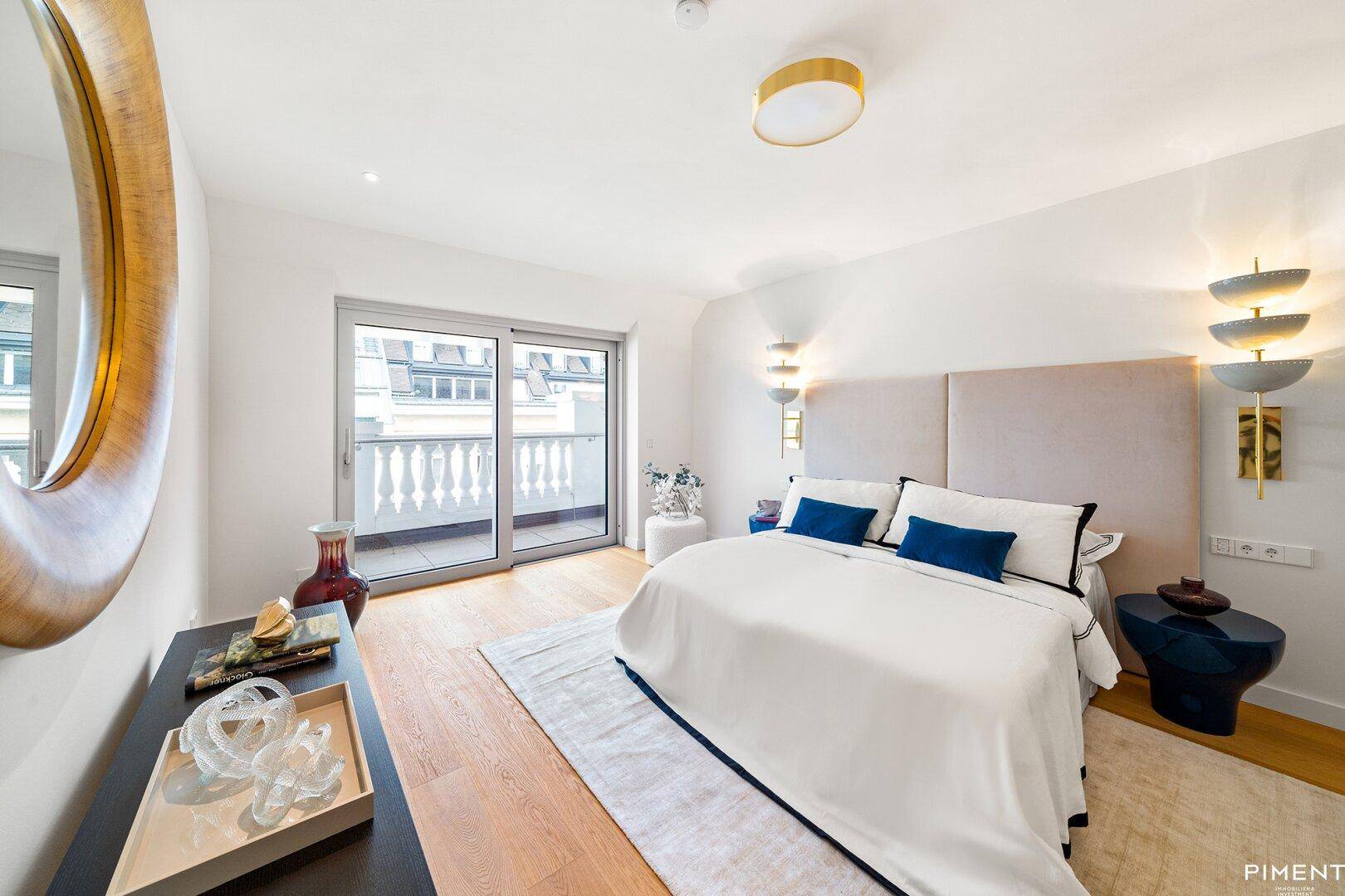 Helles Schlafzimmer mit Holzboden, modernem Bett und Zugang zu einem Balkon.