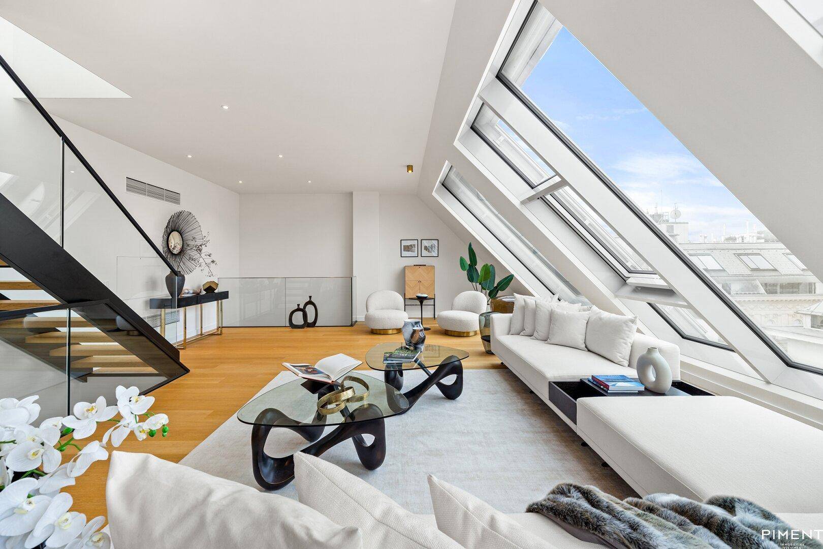 Stilvolles Wohnzimmer mit großen Dachschrägenfenstern und modernem Interieur.
