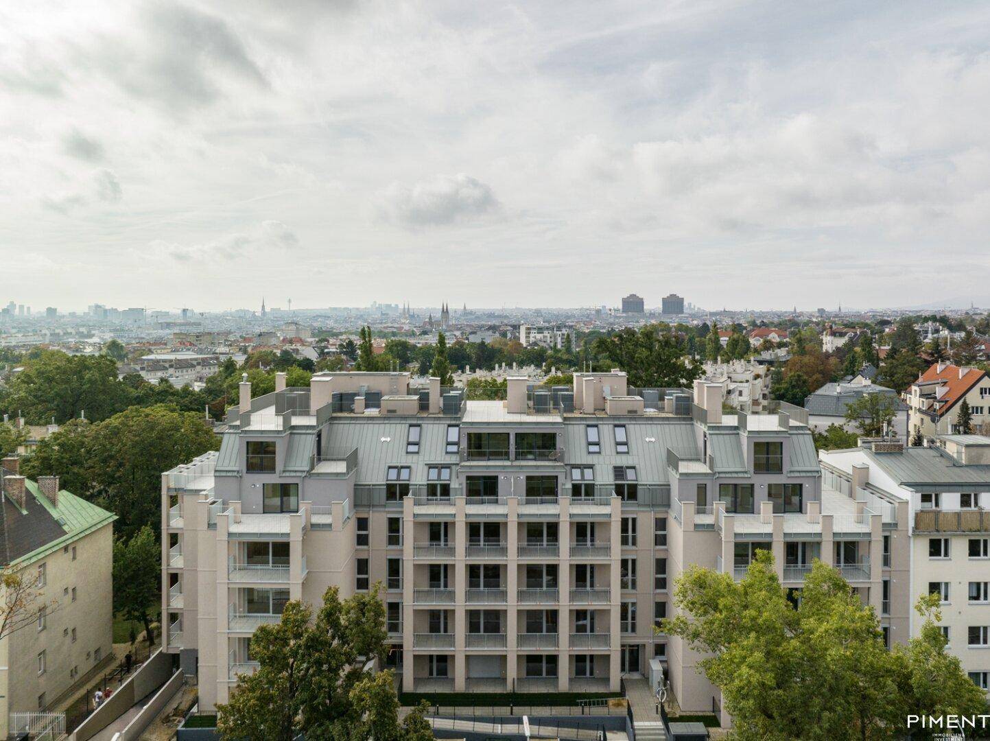 Panoramablick auf ein modernes Wohngebäude mit Dachterrassen und die umliegende Stadtlandschaft.