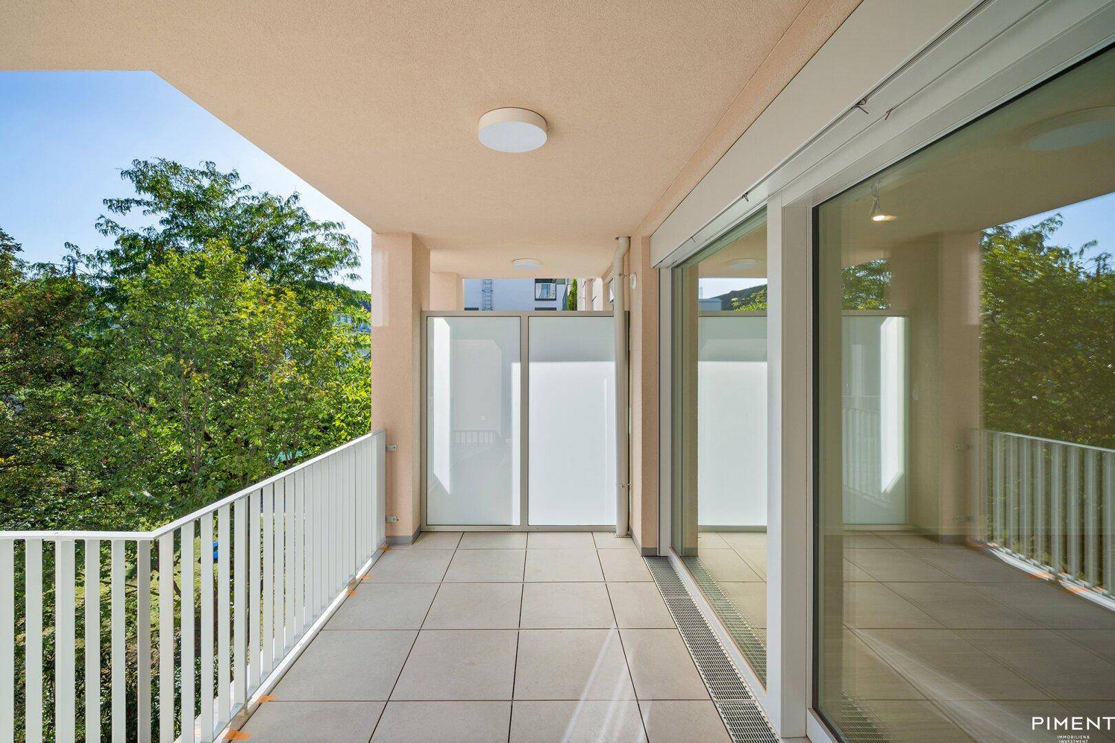 Geräumiger Balkon mit Fliesenboden und Blick ins Grüne, perfekt für entspannte Stunden im Freien.