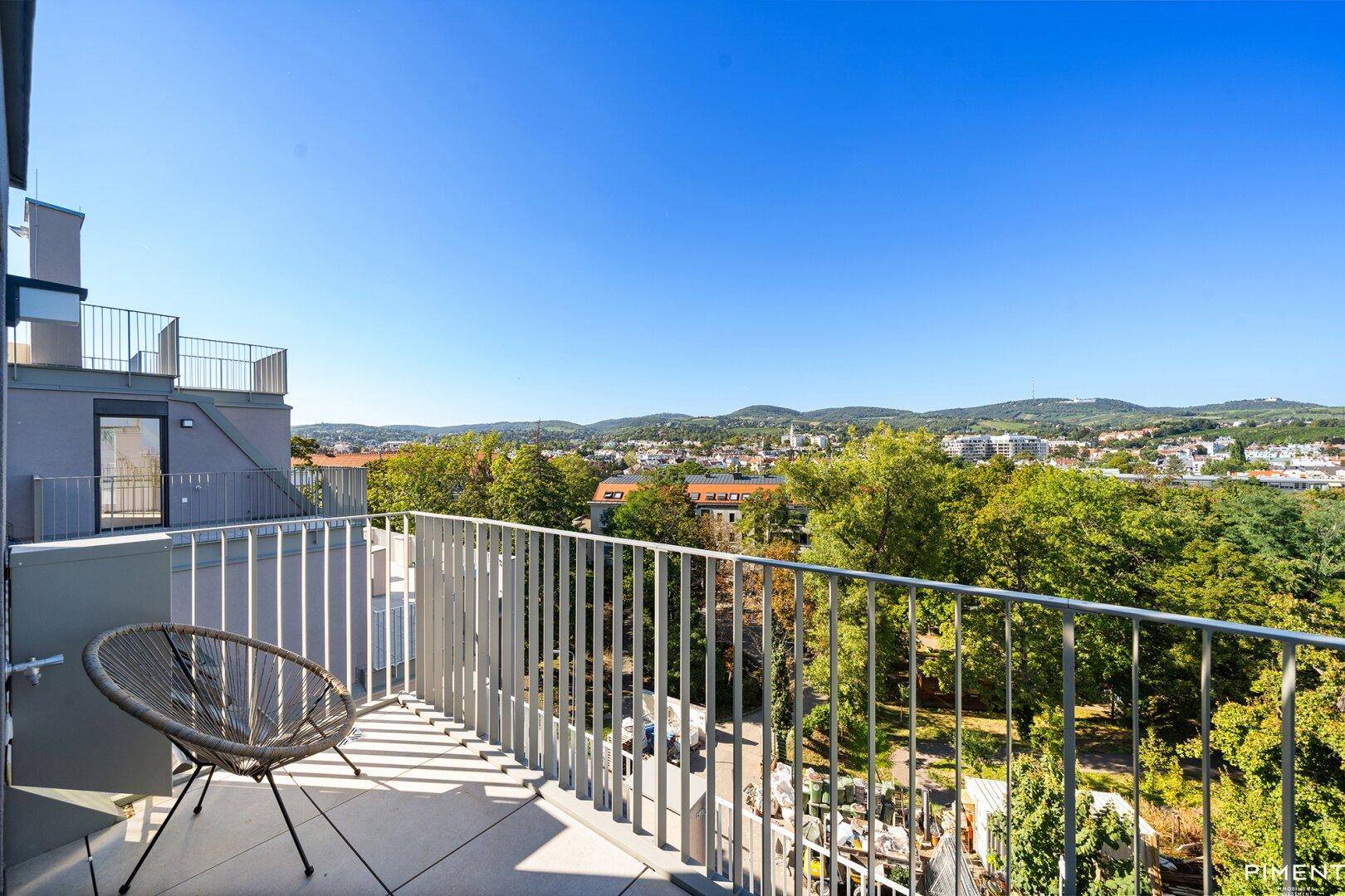 Geräumiger Balkon mit Metallgeländer und Panoramablick auf die grüne Umgebung.