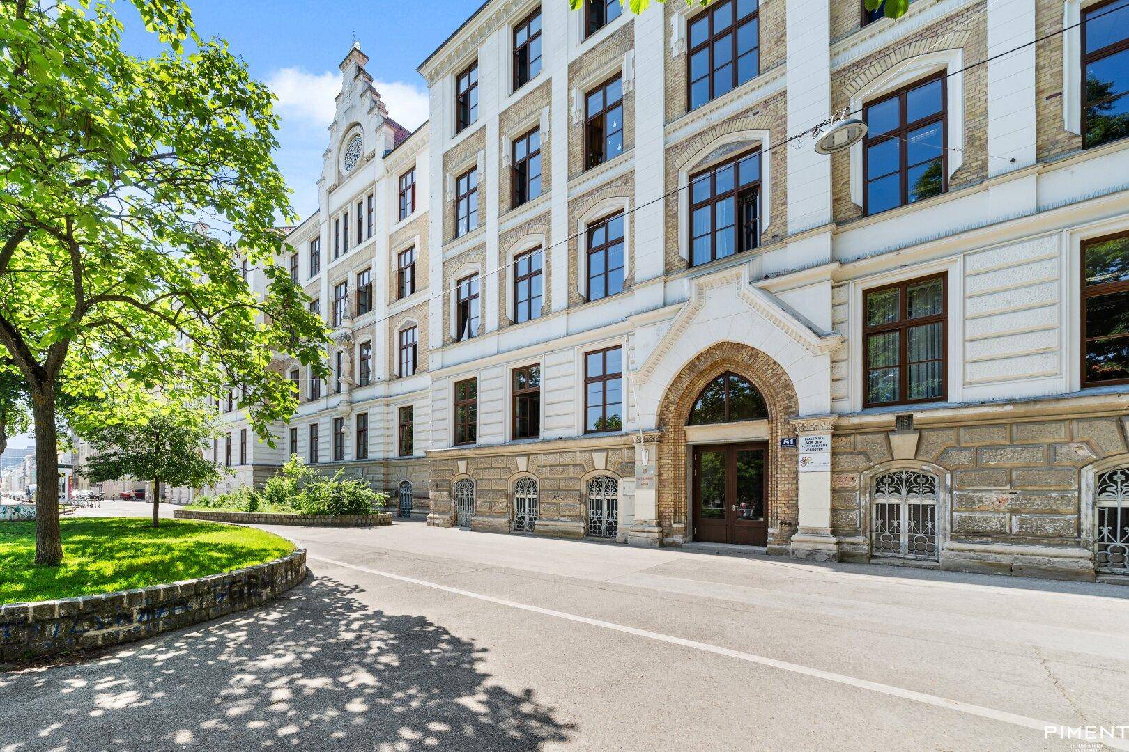 Eindrucksvolle historische Fassade eines Gebäudes mit klassischer Architektur und einem markanten Torbogen.