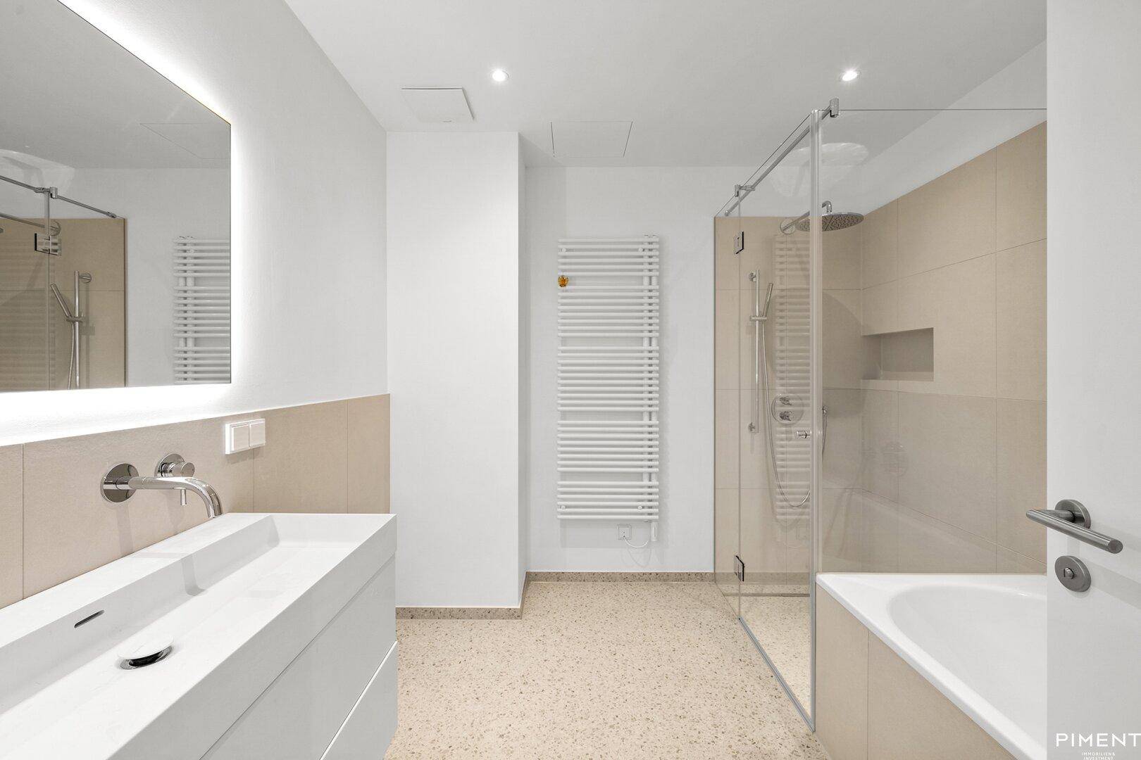 Modernes Badezimmer mit begehbarer Dusche, Badewanne, Doppelwaschbecken und beheiztem Handtuchhalter.