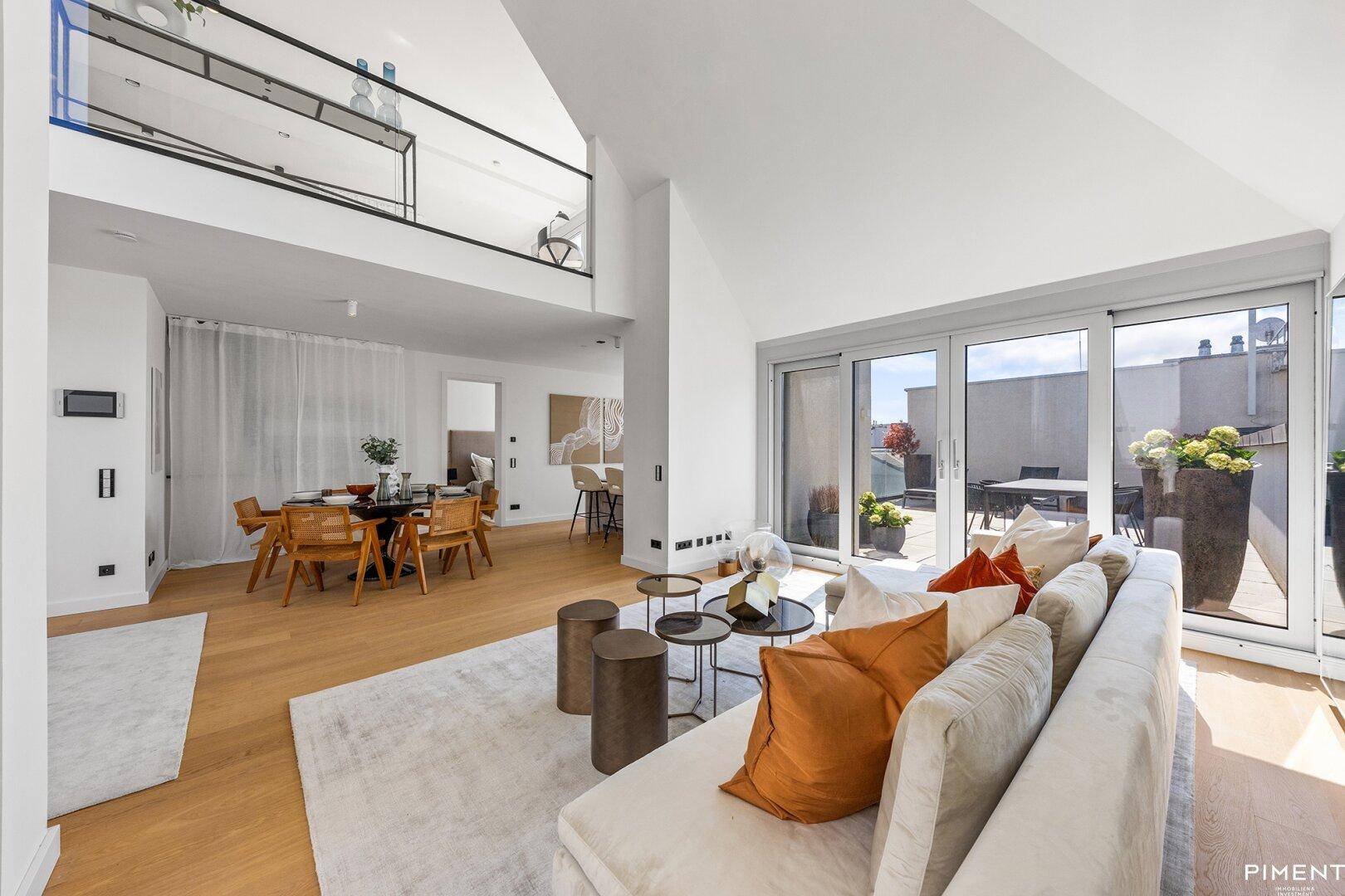 Offener Wohn- und Essbereich mit hohen Decken, Holzboden und direktem Zugang zur Terrasse.