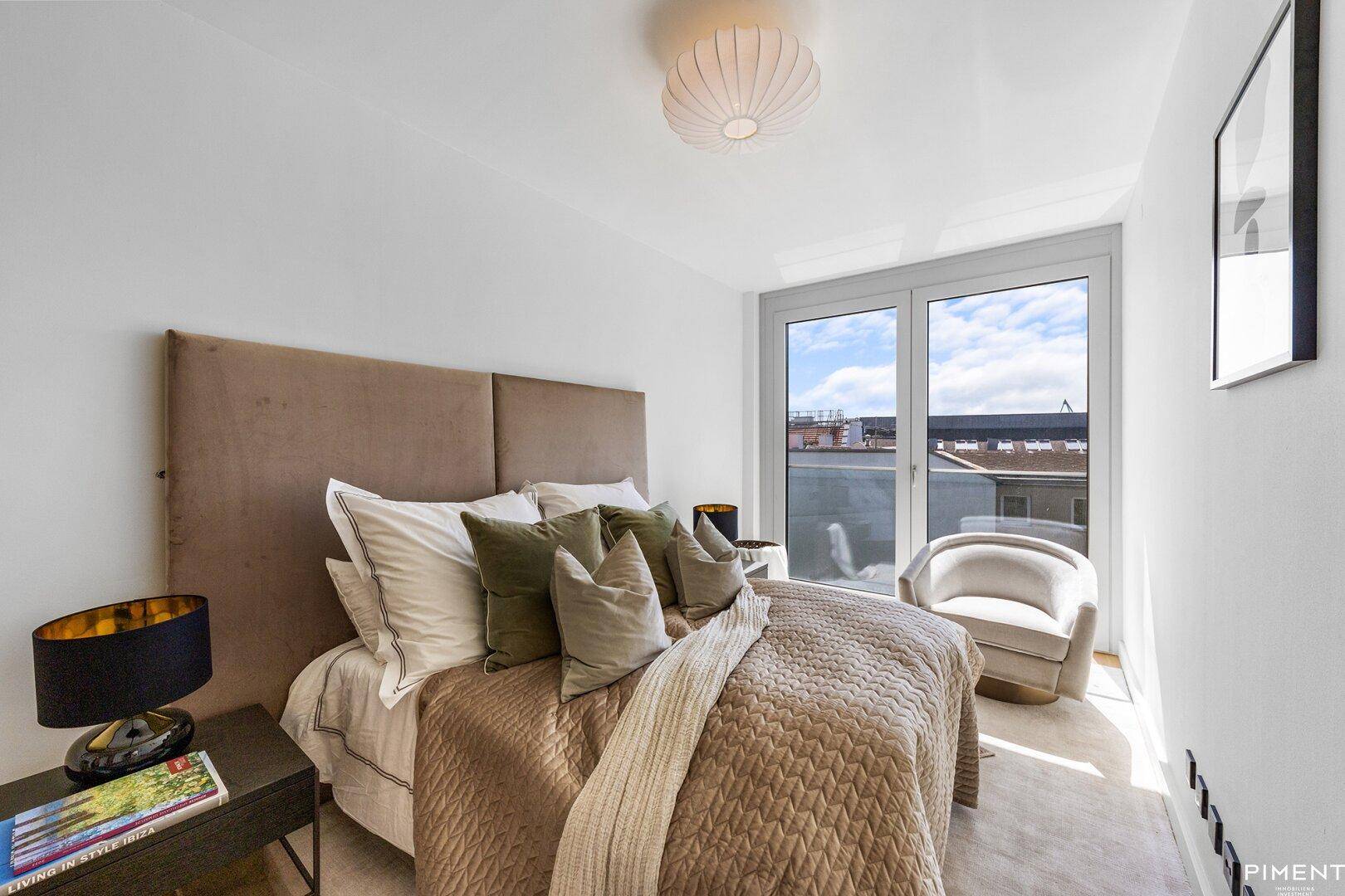 Gemütliches Schlafzimmer mit weichem Teppich, großem Bett und Fenster für natürliches Licht.