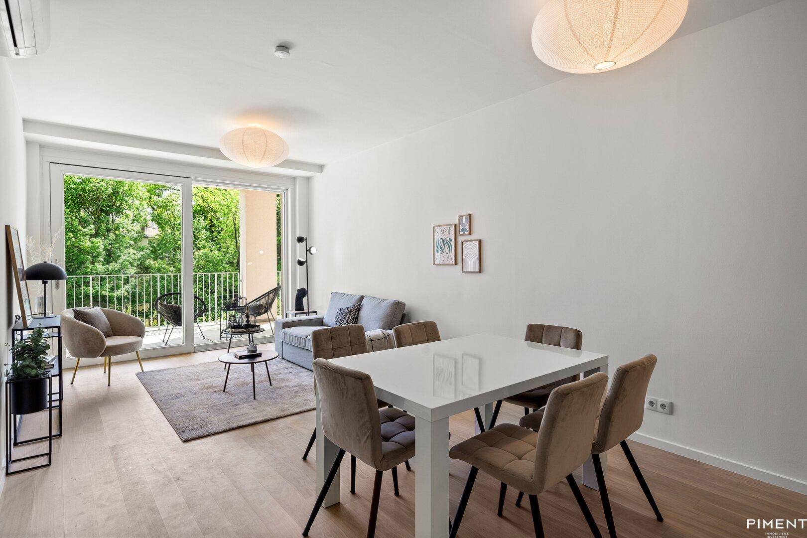 Moderner Wohn- und Essbereich mit hellem Holzboden und direktem Zugang zum Balkon.