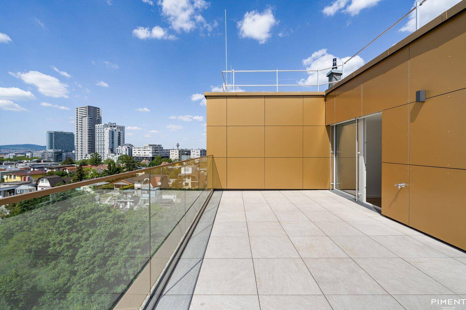 Weitläufige Dachterrasse mit moderner Verkleidung und Panoramablick über die Stadt bei strahlendem Sonnenschein.