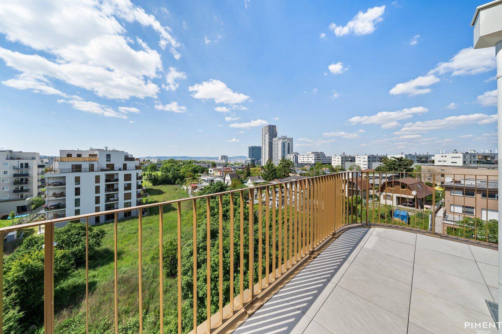 Weitläufige Dachterrasse mit moderner Brüstung und Panoramablick über die Stadt und grüne Flächen.