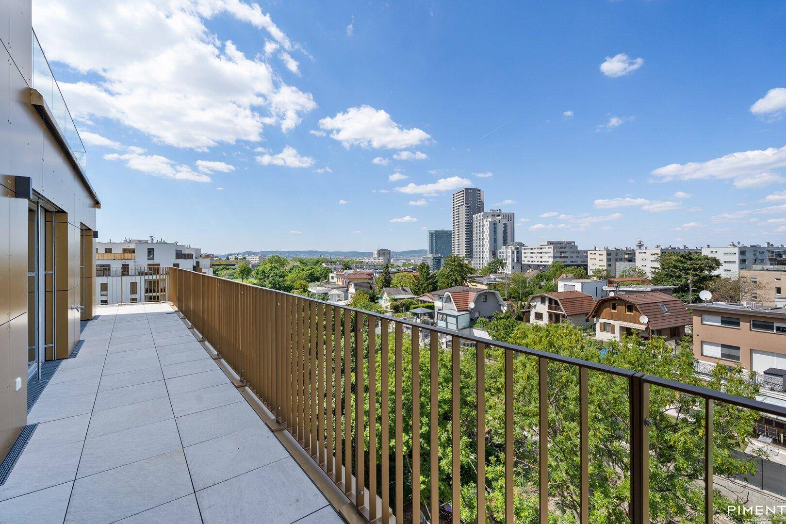 Große Terrasse mit moderner Brüstung und weitem Blick über die Stadt und grüne Landschaften.