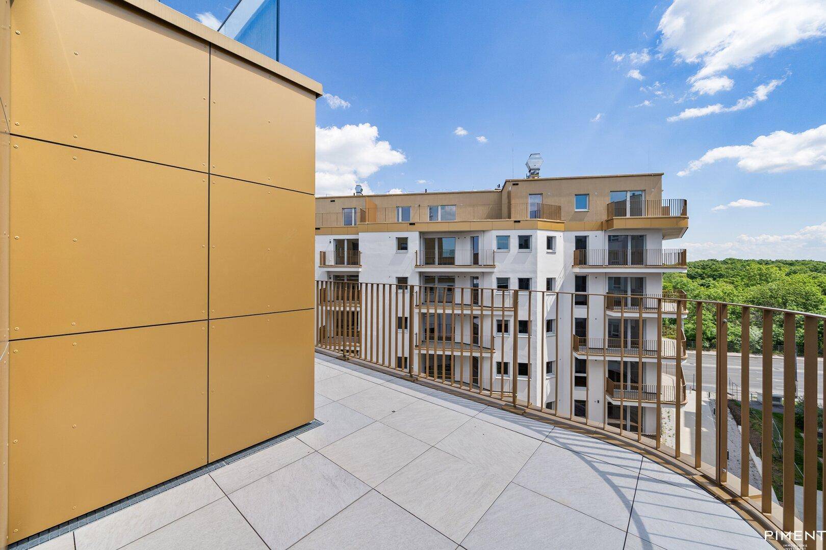 Geräumige Dachterrasse mit modernen Fliesen und Blick auf die umliegenden Gebäude unter blauem Himmel.