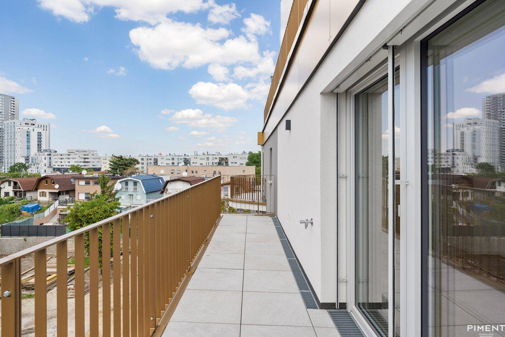 Geräumiger Balkon mit Fliesenboden und Blick auf die umliegende Wohnbebauung.