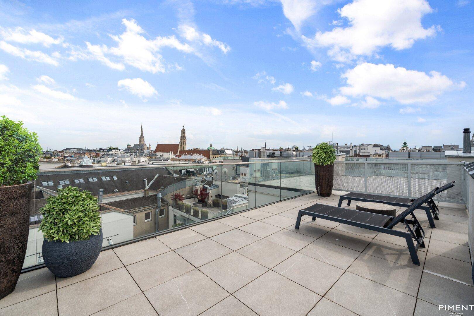 Große Dachterrasse mit Sonnenliegen und beeindruckendem Panoramablick über die Stadt.